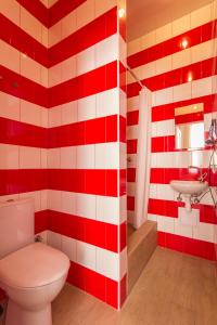 a red and white bathroom with a toilet and sink at Апартаменти для пари в центральній частині Львова in Lviv