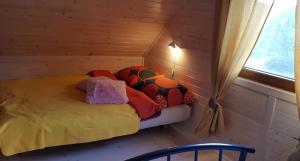a small bed in a room with a window at Domek na Cichej Leśniewo in Leśniewo
