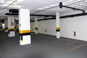 an empty parking garage with white and yellow columns at Pajucara Flat in Maceió