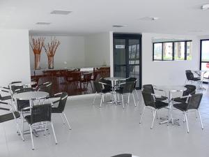 un comedor con mesas y sillas en una habitación en Pajucara Flat, en Maceió