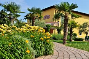 a brick walkway in front of a building with palm trees at Mobilhome Victoria Bella Italia in Peschiera del Garda