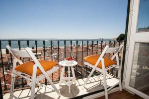 a balcony with two chairs and a table at Localtraveling Remedios in Lisbon