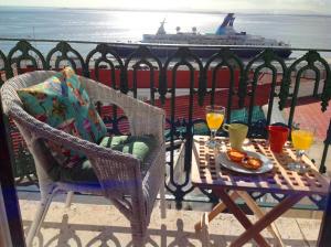 a table and chairs with drinks and a cruise ship at Localtraveling Remedios in Lisbon