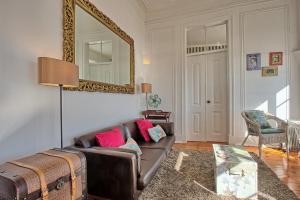 een woonkamer met een bank en een spiegel bij Localtraveling ALFAMA River View - Family Apartments in Lissabon