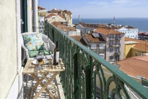 een balkon met een tafel en een glas wijn bij Localtraveling ALFAMA River View - Family Apartments in Lissabon