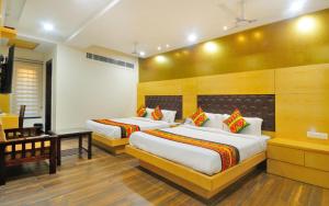 um quarto de hotel com duas camas e uma secretária em The Grand Uddhav em Nova Deli