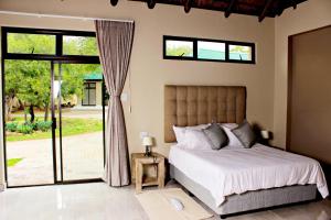 a bedroom with a bed and a sliding glass door at Zoe Bush Lodge in Pretoria