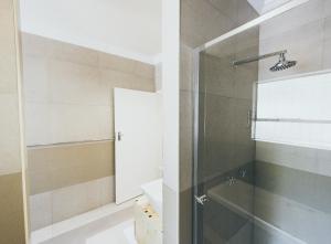baño con ducha y puerta de cristal en B and B Sandton, en Johannesburgo