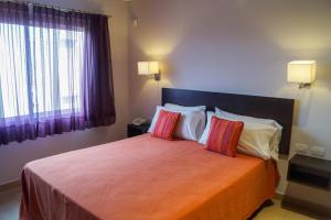 1 dormitorio con 1 cama grande y 2 almohadas en Morada Sur Apart Hotel en Las Gaviotas