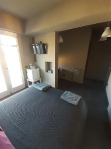 a bedroom with a large bed with a large window at CameLia in Ivrea