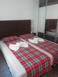 a bed with white towels on top of it at Apartman Centar 2 in Užice