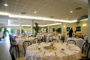 a dining room with tables and chairs with white table linen at Victoria Mobilehome Tortoreto Lido in Tortoreto Lido