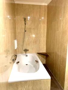 y baño con bañera y ducha. en Pacific Hotel Ambon en Ambon