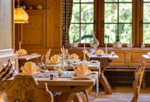 a dining room with tables and chairs and windows at Appartements Waldrose in Titisee-Neustadt