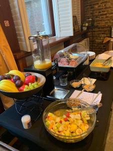 a table topped with bowls of fruit and a blender at Charming Suites Jan Zonder Vrees in Antwerp