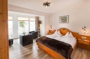 a bedroom with a bed and a living room at Sporthotel Snowwhite in Obertauern +45 photos