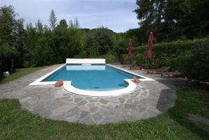 a swimming pool in a yard with two umbrellas at Guest House Patrizia in Crocefieschi