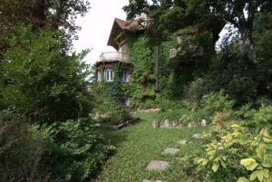 an old house covered in ivy with a yard at Guest House Patrizia in Crocefieschi