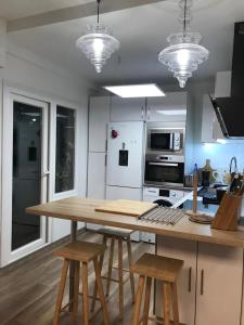 cocina con mesa de madera y 2 taburetes en Casa Jardín, en Logroño