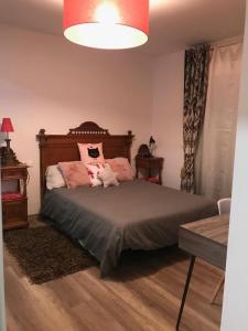 a bedroom with a bed with pink pillows on it at Casa Jardín in Logroño