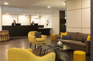 a lobby with couches and chairs and a counter at Citadines Bastille Marais Paris in Paris