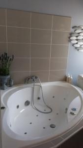 a white bath tub with a faucet in a bathroom at Chambres d'hôtes La Bourbelle in Neufmoutiers-en-Brie