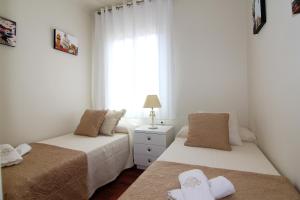 2 letti in una piccola camera con finestra di Classbedroom Fira Business Apartment a Barcellona