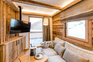 un soggiorno con divano e TV a schermo piatto di Hotel Leitenhof 4 Sterne Superior a Scheffau am Wilden Kaiser