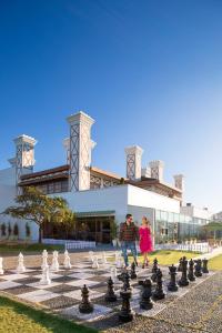 a couple playing chess on a giant chessboard in front of a building at Jaypee Residency Manor in Mussoorie