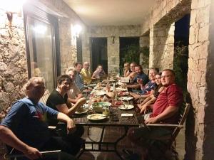 Un groupe de personnes assises autour d'une longue table dans l'établissement Castelia, à Lumio