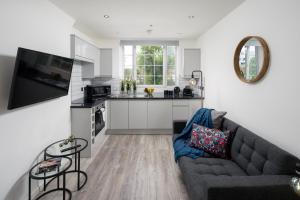 a living room with a couch and a kitchen at Skyline Serviced Apartments - Beckett in London