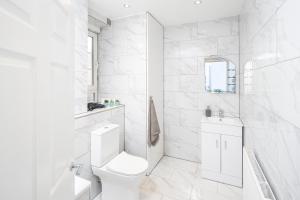 Baño blanco con aseo y lavamanos en Skyline Serviced Apartments - Beckett, en Londres