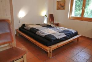 un letto su una struttura in legno in una stanza di Principala 5 Zeller Andiast - Ferienwohnung für max. 10 Personen ad Andest
