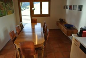 uma sala de jantar com uma mesa de madeira e cadeiras em Principala 5 Zeller Andiast - Ferienwohnung für max. 10 Personen em Andest