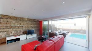 uma sala de estar com um sofá vermelho e uma televisão em Luxury BKM in Playa del Duque em Adeje