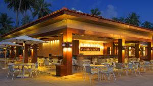 a restaurant with tables and chairs and a bar at Jatiuca Hotel & Resort in Maceió