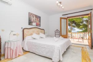 a bedroom with a bed and a balcony at Chilllife in Port d'Alcudia