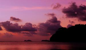 una puesta de sol sobre el océano con nubes en el cielo en Sarikantang Resort & Spa, Koh Phangan en Haad Rin