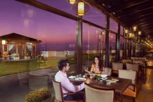 a man and woman sitting at a table in a restaurant at Jaypee Residency Manor in Mussoorie