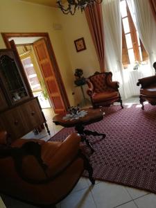 sala de estar con 2 sillas y mesa en B&B Domus Deiana, en Mamoiada