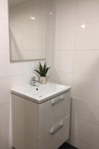 La salle de bains blanche est pourvue d'un lavabo et d'un miroir. dans l'établissement Central sweet BNB, à Amsterdam