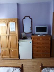 a room with a refrigerator and a tv and a mirror at Къща за гости Ганчеви in Sozopol