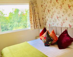 - une chambre avec un lit doté d'oreillers et d'une fenêtre dans l'établissement Homely Birch Close House with Free Parking,Garden & Sleeps 8, à Cambridge