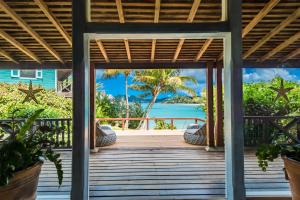 Cocobay Resort Antigua - All Inclusive - Adults Only في Johnsons Point: شرفة خشبية مطلة على المحيط