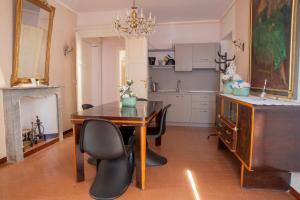 a dining room with a table and chairs and a kitchen at Bed & Roses Meni in La Morra