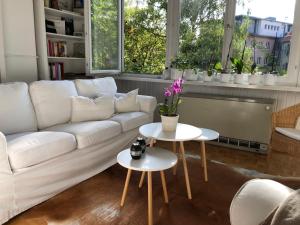 salon z białą kanapą i dwoma stołami w obiekcie KernerApartement w Stuttgarcie