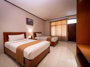 Postel nebo postele na pokoji v ubytování Yulia Beach Inn Kuta