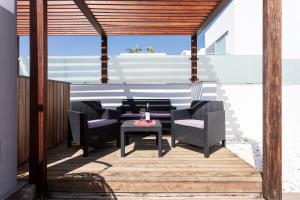 a patio with chairs and a table on a deck at Luxury BKM in Playa del Duque in Adeje