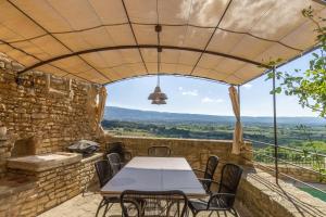 a table and chairs on a patio with a view at Maison Ventoux in Crillon-le-Brave