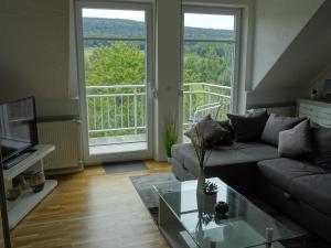 een woonkamer met een bank en een glazen tafel bij Gäste Domizil Edel Zeit in Allenbach